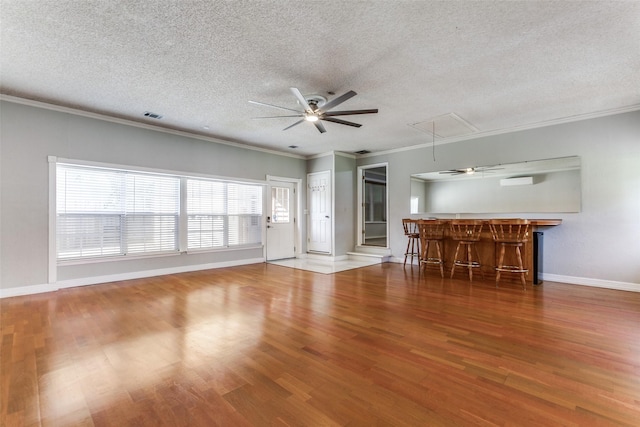 5008 Natchez Dr, Sachse, TX 75048 - unfurnished living room featuring attic access, ceiling fan, a textured ceiling, a bar, and wood finished floors
