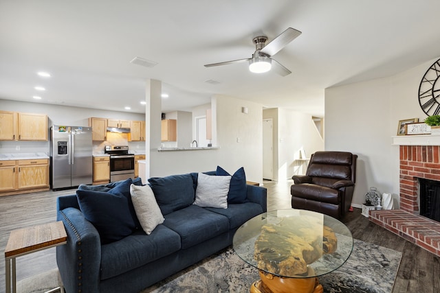 2620 Misty Harbor Dr, Little Elm, TX 75068 - living area featuring light wood-style flooring, ceiling fan, a brick fireplace, and recessed lighting