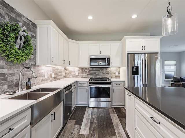 403 Sonoma Ct, Sherman, TX 75092 - kitchen featuring appliances with stainless steel finishes, dark wood-type flooring, tasteful backsplash, white cabinetry, and pendant lighting