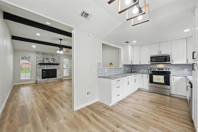 633 S Waxahachie St, Mansfield, TX 76063 - kitchen with stainless steel appliances, light wood-style floors, backsplash, light stone counters, and vaulted ceiling