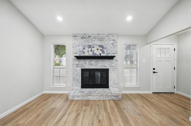 633 S Waxahachie St, Mansfield, TX 76063 - unfurnished living room with wood finished floors, a brick fireplace, recessed lighting, and lofted ceiling