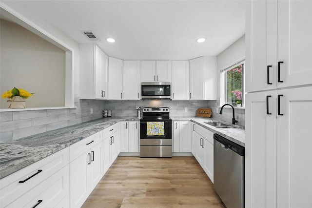 633 S Waxahachie St, Mansfield, TX 76063 - kitchen featuring appliances with stainless steel finishes, light stone countertops, white cabinets, backsplash, and recessed lighting