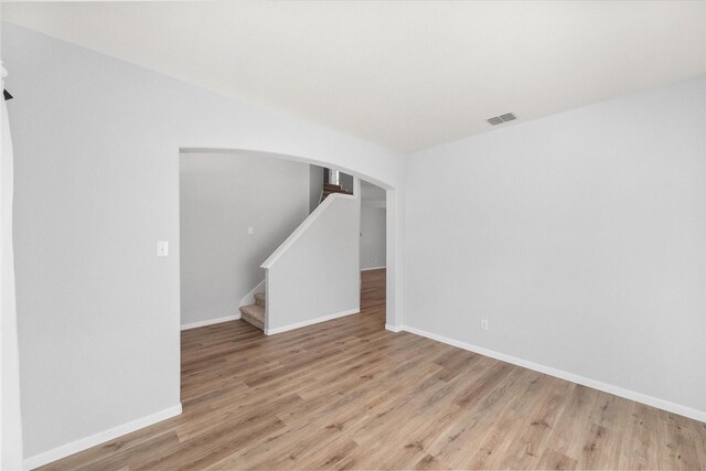 1205 Bonnet Dr, Fort Worth, TX 76131 - spare room with wood finished floors, arched walkways, and stairs