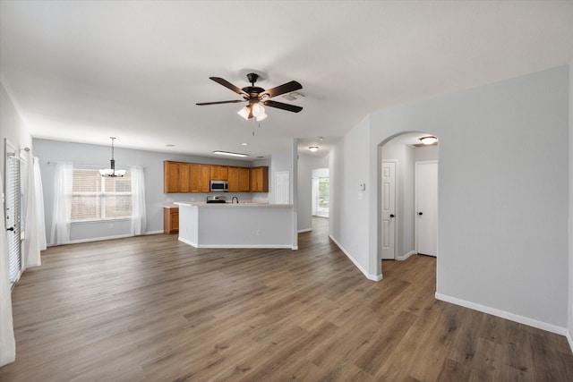 1205 Bonnet Dr, Fort Worth, TX 76131 - unfurnished living room featuring ceiling fan, arched walkways, plenty of natural light, and a chandelier