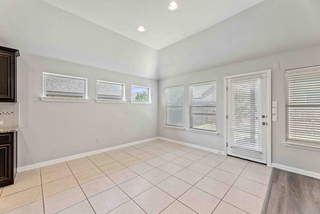 1033 Water Garden Cir, Little Elm, TX 75068 - unfurnished dining area with light tile patterned floors, recessed lighting, and vaulted ceiling