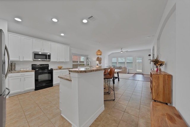 4517 Evanshire Way, Mckinney, TX 75070 - kitchen featuring stainless steel appliances, open floor plan, light tile patterned floors, decorative backsplash, and a breakfast bar