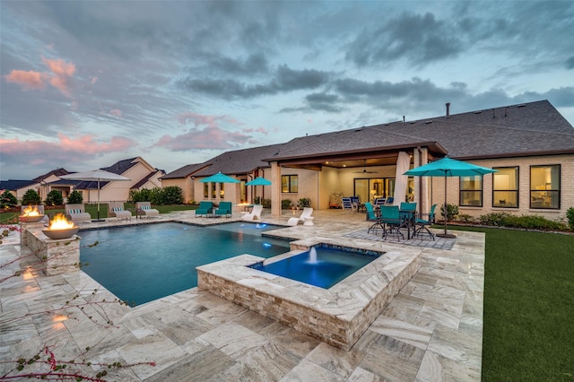 2110 Honey Ln, Celina, TX 75009 - pool at dusk featuring a fire pit, a patio area, ceiling fan, and a pool with connected hot tub