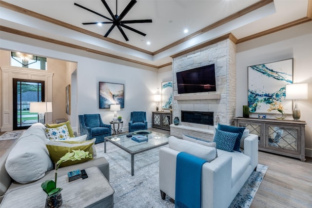 2110 Honey Ln, Celina, TX 75009 - living area with crown molding, a raised ceiling, wood finished floors, a stone fireplace, and ceiling fan