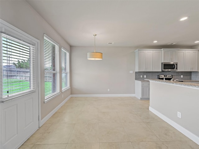 1034 Pelican Dr, Frisco, TX 75033 - kitchen with appliances with stainless steel finishes, backsplash, hanging light fixtures, light stone counters, and white cabinetry