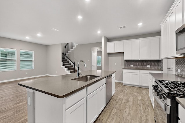 333 Edmund Ln, Fate, TX 75087 - kitchen with dark countertops, appliances with stainless steel finishes, light wood-style flooring, decorative backsplash, and recessed lighting