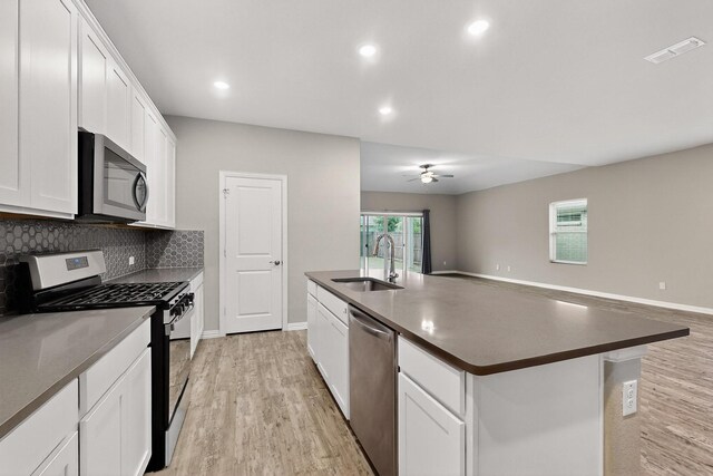 333 Edmund Ln, Fate, TX 75087 - kitchen with appliances with stainless steel finishes, dark countertops, light wood-type flooring, an island with sink, and recessed lighting