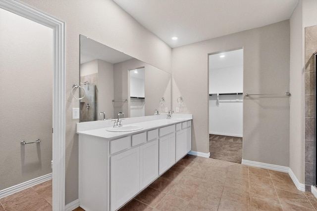 333 Edmund Ln, Fate, TX 75087 - bathroom with double vanity, a tile shower, tile patterned flooring, a spacious closet, and recessed lighting