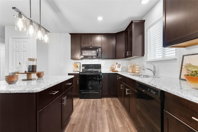 1105 Trace Dr, Aubrey, TX 76227 - kitchen with black appliances, light wood-style flooring, dark brown cabinetry, light stone countertops, and recessed lighting