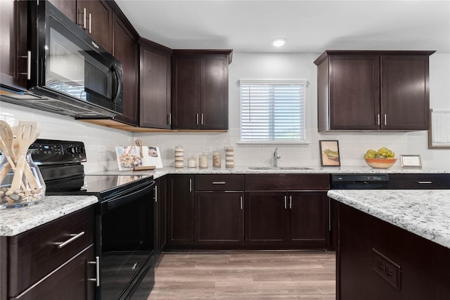 1105 Trace Dr, Aubrey, TX 76227 - kitchen with black appliances, light wood finished floors, decorative backsplash, and light stone counters