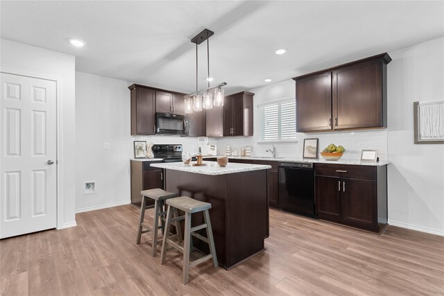 1105 Trace Dr, Aubrey, TX 76227 - kitchen with black appliances, dark brown cabinets, a kitchen island, light wood-type flooring, and recessed lighting