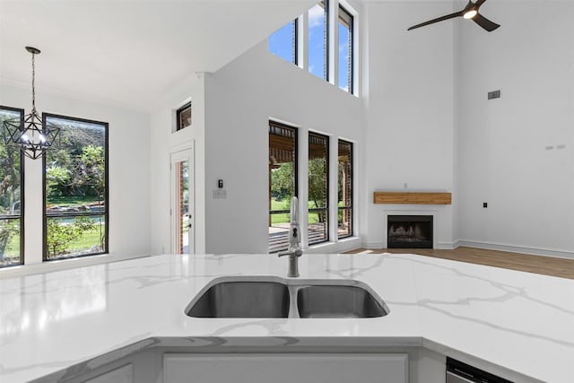 805 S Duncan Creek Ct, Weatherford, TX 76087 - kitchen with light stone countertops, hanging light fixtures, a fireplace, wood finished floors, and open floor plan