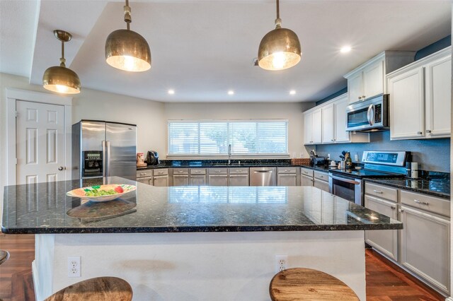 6318 White Oaks Ln, Frisco, TX 75035 - kitchen with stainless steel appliances, a large island, dark wood finished floors, dark stone counters, and recessed lighting