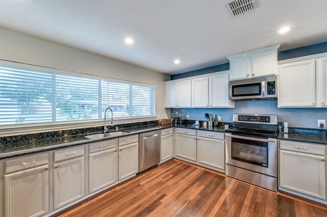 6318 White Oaks Ln, Frisco, TX 75035 - kitchen with stainless steel appliances, light wood-type flooring, white cabinets, recessed lighting, and dark stone countertops