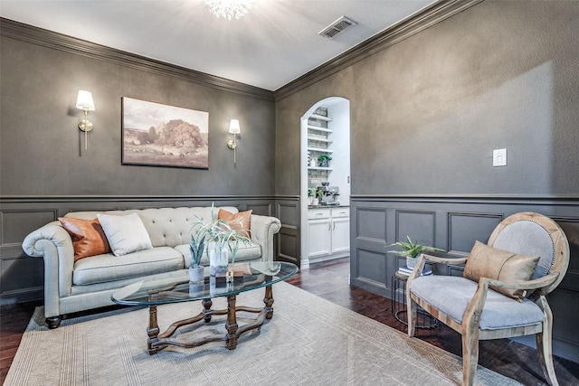 759 Bancroft Rd, Keller, TX 76248 - living room featuring dark wood-style flooring, a decorative wall, arched walkways, ornamental molding, and wainscoting