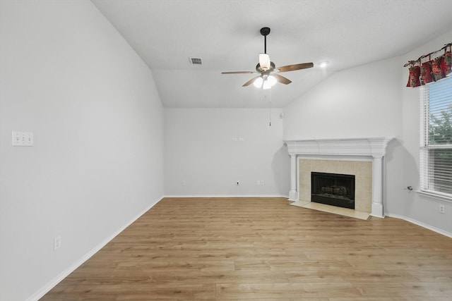 3516 San Patricio Dr, Plano, TX 75025 - unfurnished living room with lofted ceiling, a ceiling fan, light wood-style flooring, and a tiled fireplace