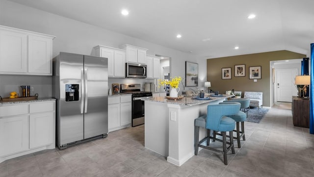 118 Gerber Ln, Boyd, TX 76023 - kitchen with stainless steel appliances, a center island, white cabinetry, a kitchen bar, and recessed lighting