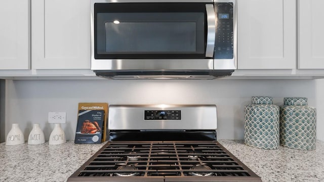 118 Gerber Ln, Boyd, TX 76023 - kitchen view of stainless steel appliances, white cabinetry, and light stone counters