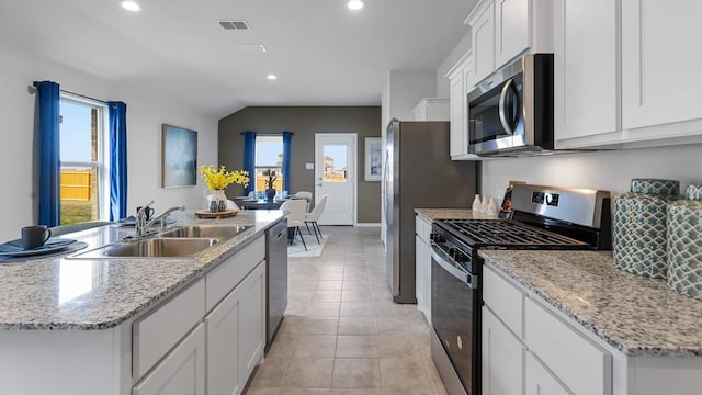 118 Gerber Ln, Boyd, TX 76023 - kitchen featuring appliances with stainless steel finishes, recessed lighting, white cabinets, lofted ceiling, and light tile patterned floors