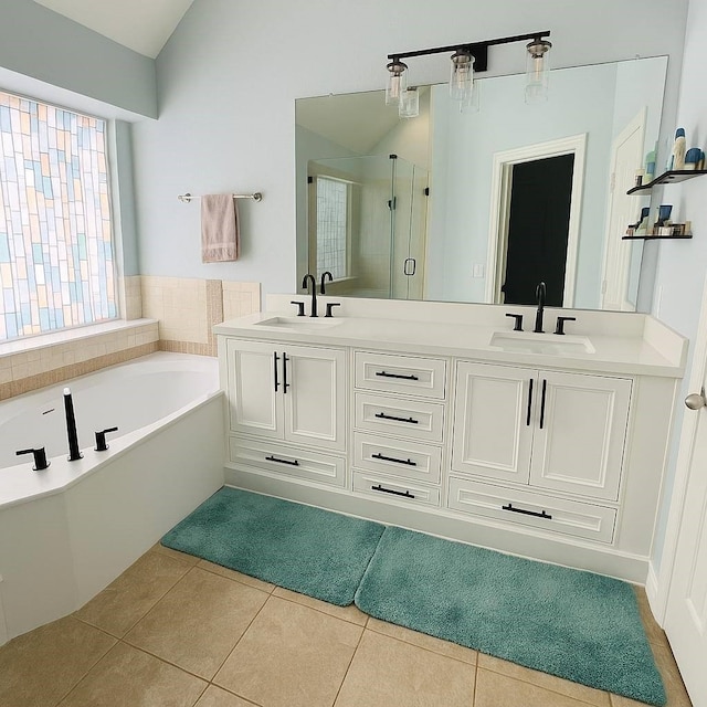 2009 Reddenson Dr, Carrollton, TX 75010 - bathroom with a shower stall, double vanity, a bath, tile patterned flooring, and vaulted ceiling
