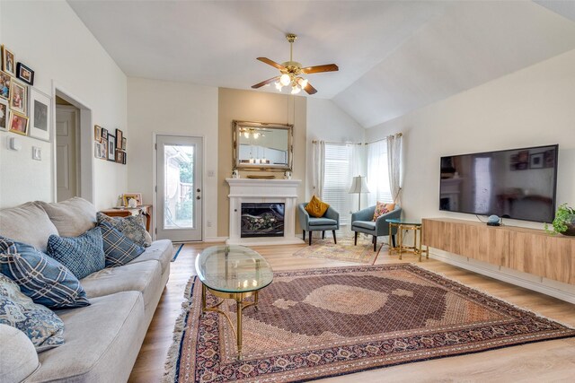 2009 Reddenson Dr, Carrollton, TX 75010 - living area with ceiling fan, healthy amount of natural light, wood finished floors, a glass covered fireplace, and vaulted ceiling