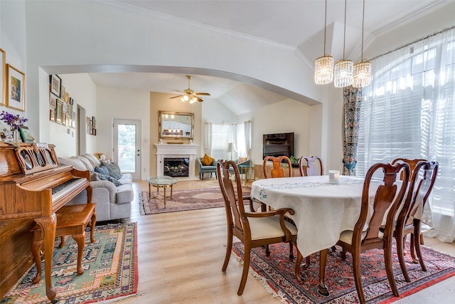 2009 Reddenson Dr, Carrollton, TX 75010 - dining space with arched walkways, lofted ceiling, crown molding, ceiling fan, and light wood-style floors