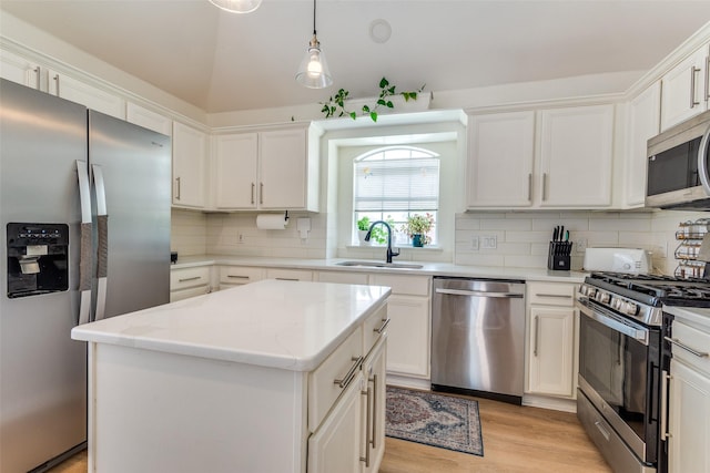 2009 Reddenson Dr, Carrollton, TX 75010 - kitchen with appliances with stainless steel finishes, backsplash, a kitchen island, light wood-style floors, and white cabinetry