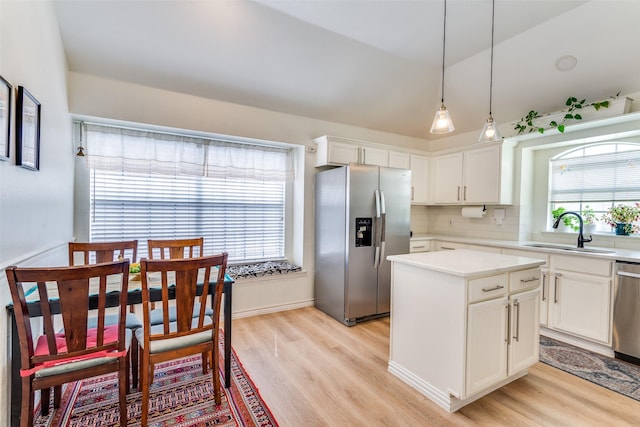 2009 Reddenson Dr, Carrollton, TX 75010 - kitchen featuring stainless steel appliances, light wood-style floors, a center island, white cabinetry, and tasteful backsplash