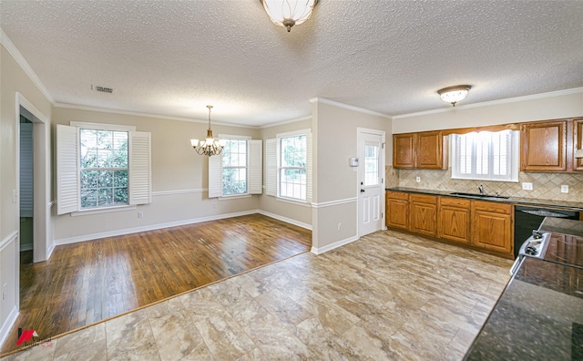 416 Albany Ave, Shreveport, LA 71105 - kitchen featuring a chandelier, brown cabinetry, plenty of natural light, backsplash, and crown molding