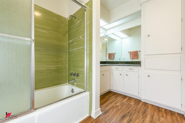 719 Edgemont St, Shreveport, LA 71106 - full bathroom with wood finished floors, combined bath / shower with glass door, vanity, and a skylight