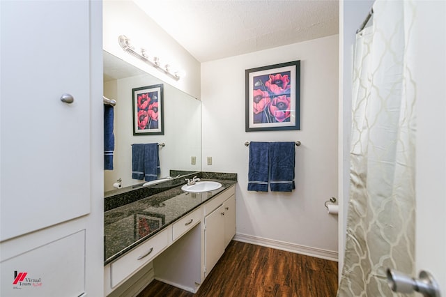719 Edgemont St, Shreveport, LA 71106 - bathroom with wood finished floors, vanity, and a textured ceiling