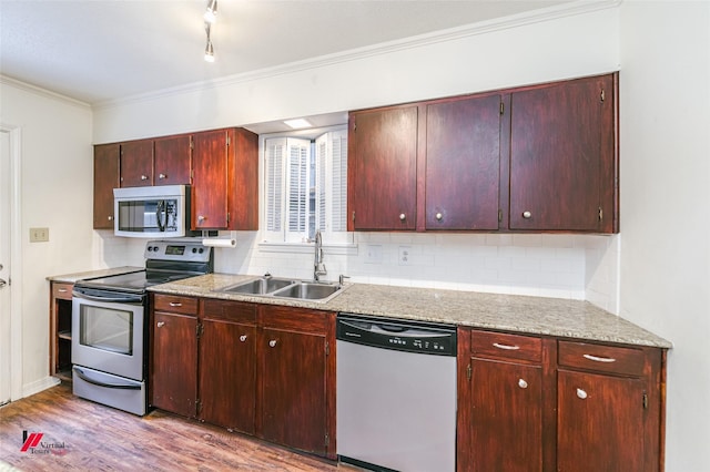 719 Edgemont St, Shreveport, LA 71106 - kitchen with appliances with stainless steel finishes, crown molding, light wood-style floors, backsplash, and light countertops