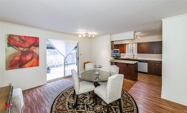 719 Edgemont St, Shreveport, LA 71106 - dining area featuring dark wood-style flooring, a textured ceiling, and a decorative wall