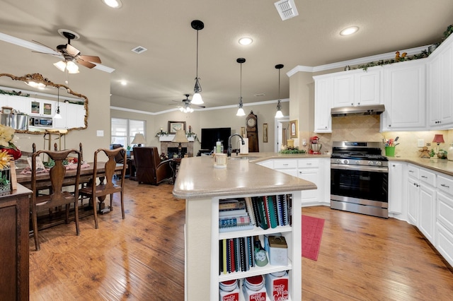 210 Oleander Pl, Waxahachie, TX 75165 - kitchen with gas range, ceiling fan, crown molding, a peninsula, and light wood-style flooring
