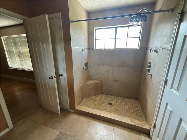 1705 Huntington Dr, Mesquite, TX 75149 - bathroom featuring a tile shower, tile patterned floors, and a textured ceiling