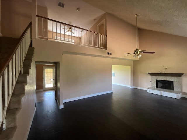 1705 Huntington Dr, Mesquite, TX 75149 - unfurnished living room with a ceiling fan, high vaulted ceiling, stairs, dark wood finished floors, and a fireplace with raised hearth