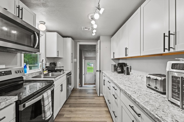 84 Kristin Dr, Pottsboro, TX 75076 - kitchen featuring stainless steel appliances, light wood-style floors, and white cabinetry