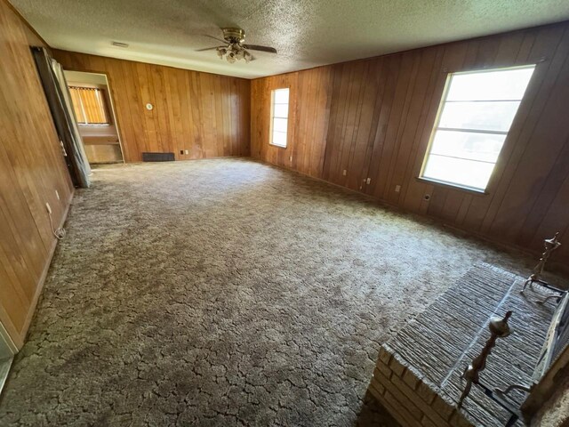 3560 Regal Rd, Fort Worth, TX 76111 - empty room with a textured ceiling, ceiling fan, wooden walls, and carpet