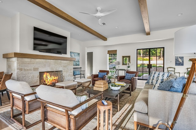 3560 Pleasant Run Cir, Athens, TX 75752 - living room with a stone fireplace, beamed ceiling, a ceiling fan, and wood finished floors