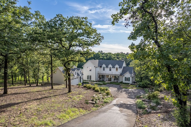 3560 Pleasant Run Cir, Athens, TX 75752 - view of front facade featuring driveway, a garage, a chimney, and view of wooded area