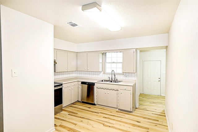 103 Wise St, Nocona, TX 76255 - kitchen with appliances with stainless steel finishes, light wood-style flooring, light countertops, and backsplash