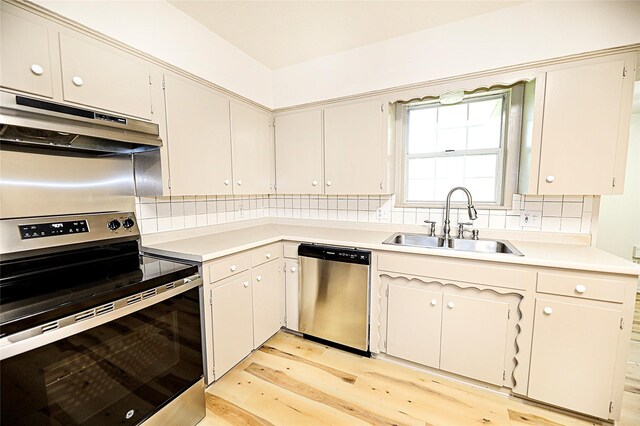 103 Wise St, Nocona, TX 76255 - kitchen with appliances with stainless steel finishes, under cabinet range hood, backsplash, light countertops, and light wood-style flooring