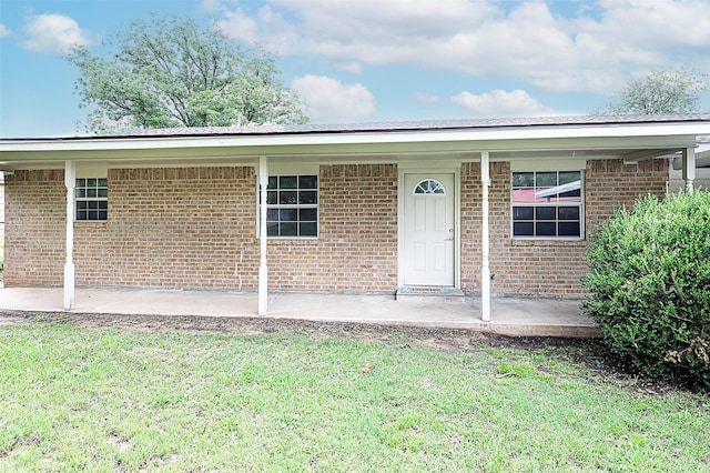 103 Wise St, Nocona, TX 76255 - doorway to property featuring a lawn and brick siding