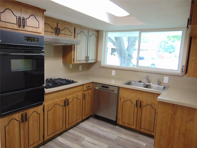 802 Acton Ave, Duncanville, TX 75137 - kitchen with black appliances, a warming drawer, light wood finished floors, brown cabinets, and light countertops