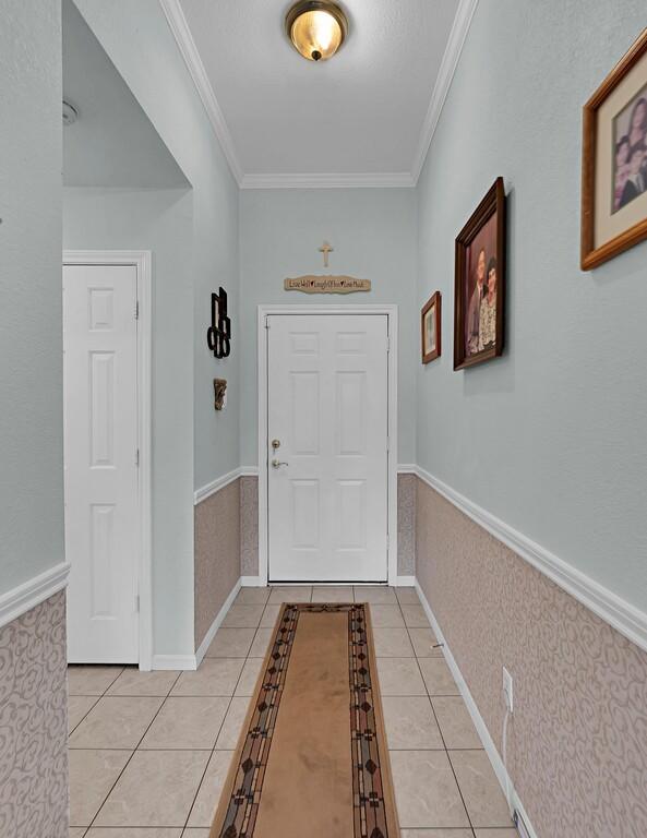 308 Greystone Dr, Lorena, TX 76655 - doorway to outside with light tile patterned floors, ornamental molding, and wainscoting