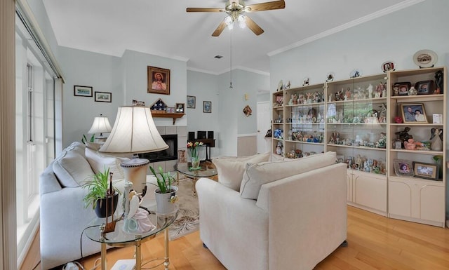 308 Greystone Dr, Lorena, TX 76655 - living area with ceiling fan, light wood-type flooring, a tiled fireplace, and ornamental molding